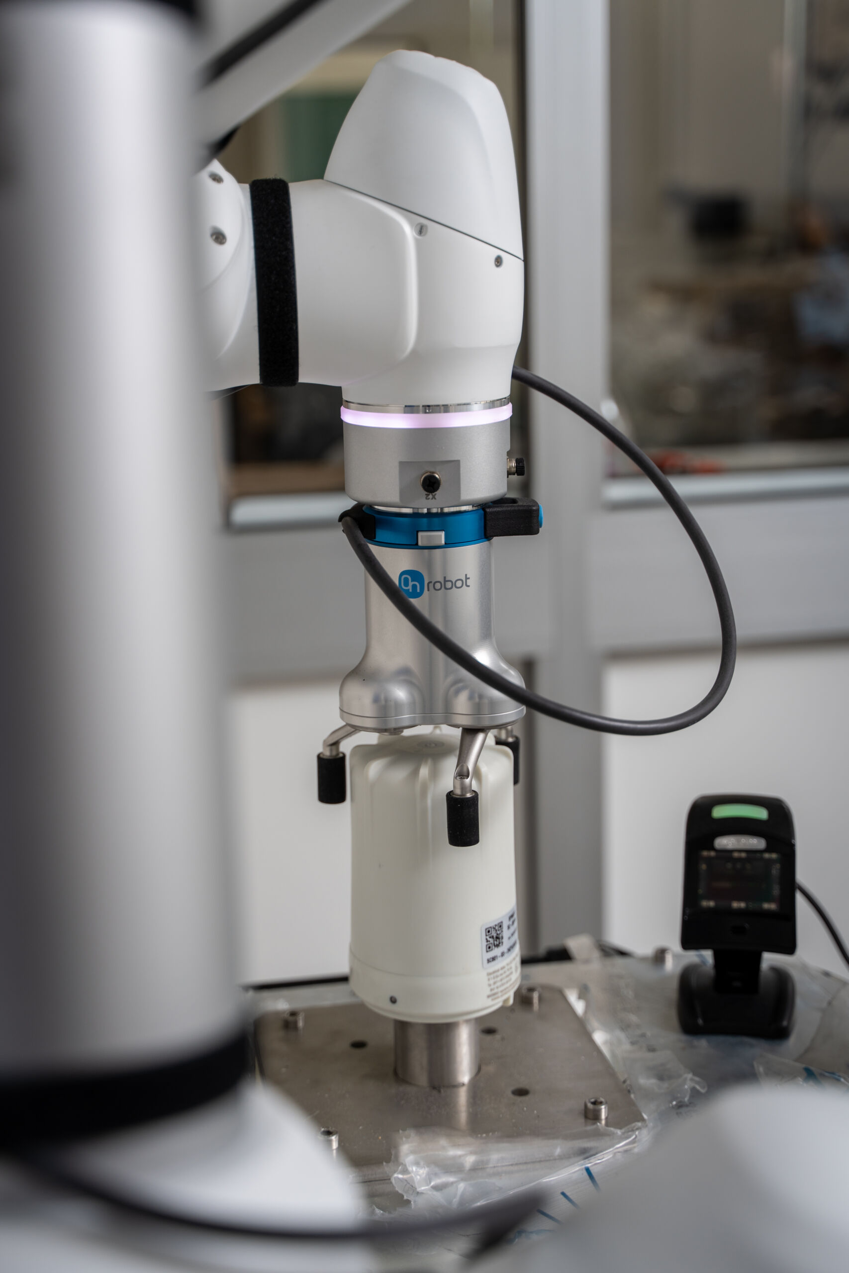 Collaborative robot performing automated testing on SPINCap electronic component